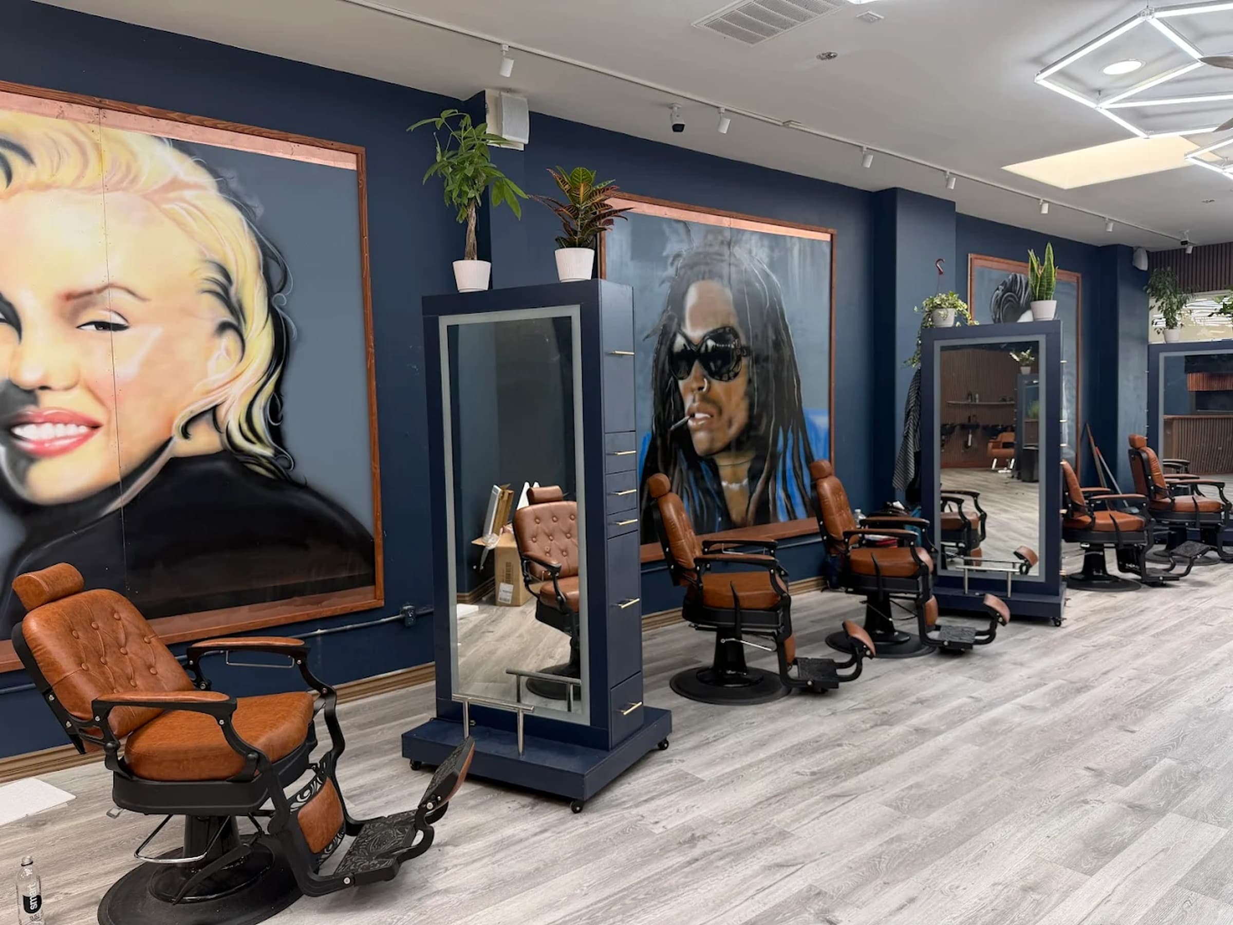 Inside Uppercuts SD — five chairs, navy walls, Marilyn and dreadlocks airbrush murals, Ocean Beach